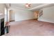 Open living room with fireplace, ceiling fan, and entry to the staircase and other rooms at 15001 Rosemary Way Dr, Huntersville, NC 28078