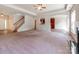 Spacious living room with fireplace, staircase, and entrance to the kitchen and front entryway at 15001 Rosemary Way Dr, Huntersville, NC 28078