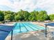 The large community pool is surrounded by mature trees, cabanas and lounge chairs at 15001 Rosemary Way Dr, Huntersville, NC 28078