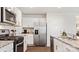 Modern kitchen featuring white cabinets, stainless steel appliances, granite countertops, and wood-style flooring at 15031 Milo Ln, Charlotte, NC 28278