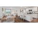 Open-concept living space with dining area, kitchen with island seating, and comfortable living room with large windows at 15031 Milo Ln, Charlotte, NC 28278