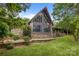 Stunning stone house with a striking window design, surrounded by lush greenery and landscaping at 1515 Heatherloch Dr, Gastonia, NC 28054