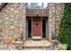 Inviting front entrance with a stone facade, decorative lanterns, and a colorful welcome mat at 1515 Heatherloch Dr, Gastonia, NC 28054