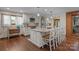 Bright kitchen with white cabinetry, granite countertops, a large island, and hardwood flooring at 1515 Heatherloch Dr, Gastonia, NC 28054