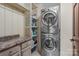 Practical laundry area with stacked washer/dryer, shelving, and countertop space at 1515 Heatherloch Dr, Gastonia, NC 28054