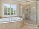 Luxurious bathroom features soaking tub, glass shower enclosure, and plantation shutters at 1522 High St, Charlotte, NC 28211