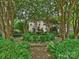 Beautifully landscaped garden featuring a central fountain and lush greenery surrounding a stone home at 1522 High St, Charlotte, NC 28211