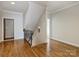 Upstairs hallway features hardwood floors and iron railing overlooking the staircase at 1522 High St, Charlotte, NC 28211