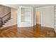 Bright living room featuring hardwood floors, custom built-ins, and a staircase at 1522 High St, Charlotte, NC 28211