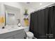 Clean bathroom featuring a single sink vanity, toilet, and shower with a black curtain at 1563 Old Rivers Rd, Concord, NC 28027