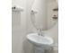 Stylish powder room with pedestal sink, round mirror, and decorative shelving at 1563 Old Rivers Rd, Concord, NC 28027