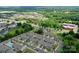 An aerial view of townhomes surrounded by lush greenery, roads, and commercial buildings within the neighborhood at 16039 Simril Ct, Charlotte, NC 28278