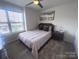 Cozy bedroom with a large window, ceiling fan, and stylish decor at 16039 Simril Ct, Charlotte, NC 28278