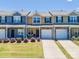 Shot of townhomes featuring manicured lawns, colorful exteriors, and attached garages at 16039 Simril Ct, Charlotte, NC 28278