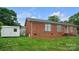 Charming single-story brick home featuring a well-maintained lawn and a detached storage shed at 1609 Mcfarland Dr, Shelby, NC 28152