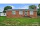 Charming single-story brick home featuring a well-maintained lawn and a detached storage shed at 1609 Mcfarland Dr, Shelby, NC 28152