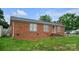 Charming single-story brick home featuring a well-maintained lawn and a detached storage shed at 1609 Mcfarland Dr, Shelby, NC 28152