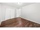 A bright bedroom is shown with wood-look floors and a double door closet at 1908 Harvest Ln # 5, Charlotte, NC 28210
