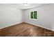 A bright bedroom is shown with wood-look floors and a window to the outside at 1908 Harvest Ln # 5, Charlotte, NC 28210