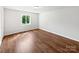 A bright bedroom is shown with wood-look floors and a window to the outside at 1908 Harvest Ln # 5, Charlotte, NC 28210