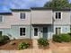 Charming townhome featuring light blue and gray siding, bright windows, and a welcoming front entrance with lovely landscaping at 1908 Harvest Ln # 5, Charlotte, NC 28210