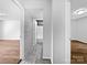 A hallway is shown with wood-look floors and access to the bathroom and other rooms at 1908 Harvest Ln # 5, Charlotte, NC 28210