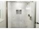 Elegant bathroom shower featuring sleek glass doors, marble-like tile, and recessed niche for toiletries at 1936 Russell Ave, Charlotte, NC 28216