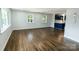 Spacious living room featuring refinished hardwood floors, fresh paint, and natural light from large windows at 1936 Russell Ave, Charlotte, NC 28216