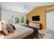 Bedroom with large window, ceiling fan, mounted TV, and a warm color palette at 2013 Arbor Crest Ct, Charlotte, NC 28262