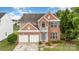 Charming brick two-story home featuring a two-car garage and a small balcony overlooking the front yard at 2013 Arbor Crest Ct, Charlotte, NC 28262