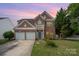 Charming brick two-story home featuring a two-car garage and a small balcony overlooking the front yard at 2013 Arbor Crest Ct, Charlotte, NC 28262