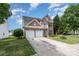 Charming brick two-story home featuring a two-car garage and a small balcony overlooking the front yard at 2013 Arbor Crest Ct, Charlotte, NC 28262