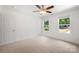 Bright bedroom featuring two windows allowing plenty of natural light, neutral walls, carpeted floors, and a ceiling fan at 208 N Correll St, Landis, NC 28025