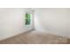 Simple bedroom with neutral carpeting and a window offering green outdoor views at 208 N Correll St, Landis, NC 28025