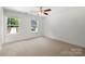 Spacious bedroom featuring two windows allowing plenty of natural light, neutral walls, carpeted floors, and a ceiling fan at 208 N Correll St, Landis, NC 28025