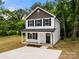 Charming two-story home featuring a classic white facade, black shutters and a welcoming covered front porch at 208 N Correll St, Landis, NC 28025
