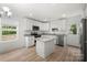 Well-lit kitchen featuring white cabinets, stainless steel appliances, granite countertops, and a functional kitchen island at 208 N Correll St, Landis, NC 28025