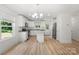 Bright kitchen with white cabinets, stainless steel appliances, a granite countertop island, and wood grain floors at 208 N Correll St, Landis, NC 28025