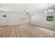 Bright living room with light wood flooring, a ceiling fan, a chandelier, and abundant natural light through windows at 208 N Correll St, Landis, NC 28025