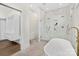 Modern bathroom featuring a glass shower and a soaking tub with gold fixtures at 2414 E 7Th St, Charlotte, NC 28204