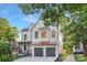 Stunning white brick home with a two-car garage and copper roof accents under a bright blue sky at 2414 E 7Th St, Charlotte, NC 28204