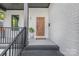 Charming front porch with painted brick, stylish wooden front door, and welcoming decor at 2414 E 7Th St, Charlotte, NC 28204