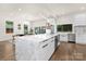 Open kitchen with a marble island, stainless steel appliances, white cabinetry, and an adjacent dining area at 2414 E 7Th St, Charlotte, NC 28204