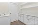 Laundry area with white cabinets, quartz countertops, a sink, and floating shelves at 2414 E 7Th St, Charlotte, NC 28204