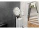 Modern powder room featuring dark gray tiling, a unique vessel sink, and a round LED mirror at 2414 E 7Th St, Charlotte, NC 28204