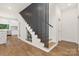 Stylish staircase with a modern railing design and a built-in wine cellar underneath the steps at 2414 E 7Th St, Charlotte, NC 28204