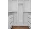 Spacious walk-in closet with custom built-in shelving and drawers on hardwood floors at 2414 E 7Th St, Charlotte, NC 28204