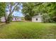Spacious backyard featuring lush lawn, mature trees, and a detached garage, perfect for outdoor activities and storage at 2601 Ashley Rd, Charlotte, NC 28208