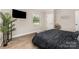 Bedroom with hardwood floors, large window, mounted television, and stylish decor at 2601 Ashley Rd, Charlotte, NC 28208