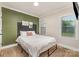 Bedroom features hardwood floors, a large window, and a sage accent wall at 2601 Ashley Rd, Charlotte, NC 28208